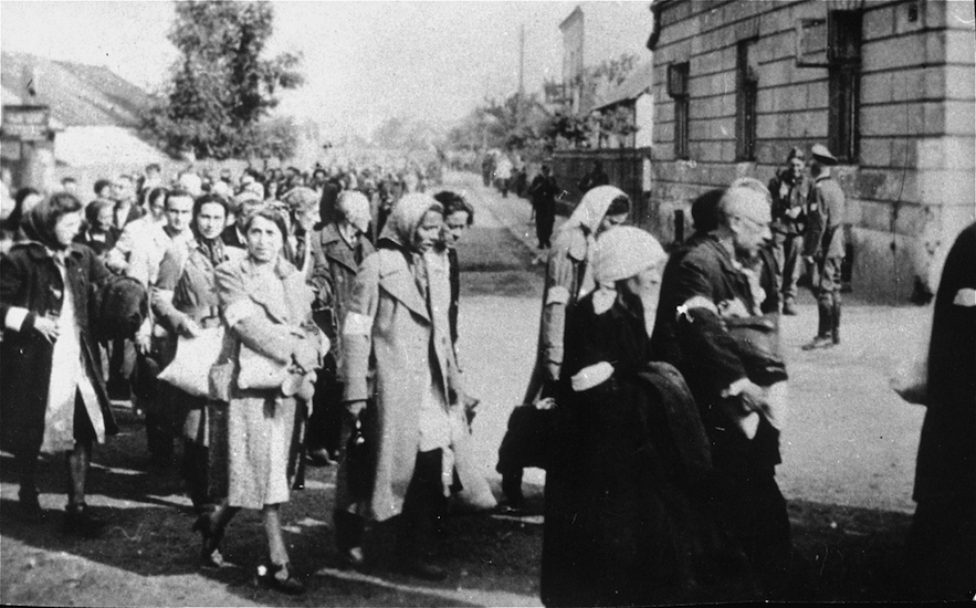 Jews walk in a long column through the streets of Rzeszow during a deportation action from the ghetto. July 1942