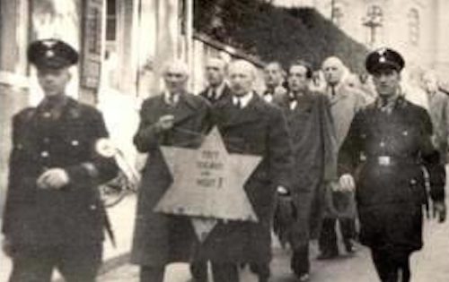 Jews being forced to walk with the star of David during the Kristallnacht in Nazi-Germany on the night of 9-10 November, 1938. See page for author [public domain], via Wikimedia Commons.